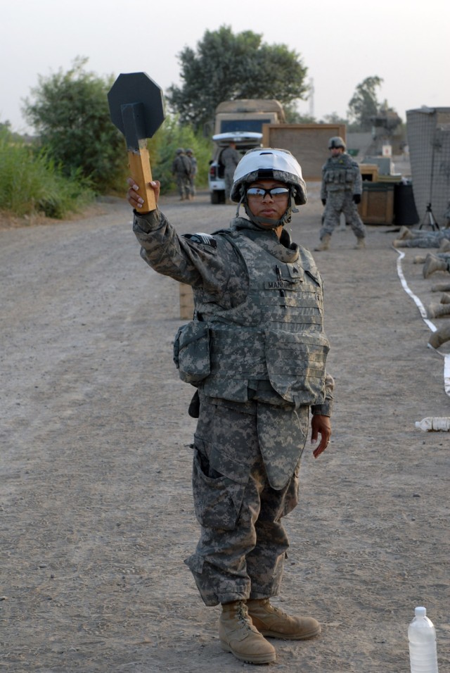 BAGHDAD - Sgt. Tanisha Manning, from Oakland, Calif., assigned to Company B, Division Special Troops Battalion, 1st Cavalry Division, signals to the range noncommissioned officer-in-charge that her lane is not yet ready during a zero and...