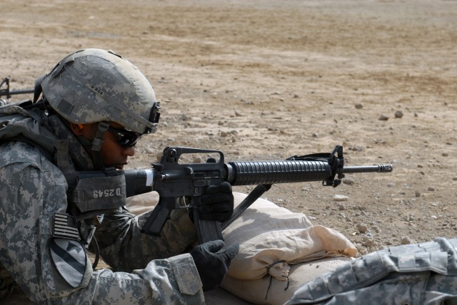 BAGHDAD - Spc. Wilbur DeShields, from Akron, Ohio, assigned to Company A, Division Special Troops Battalion, 1st Cavalry Division, locks and loads a magazine in his M-16 rifle during a zero and qualification range at Caughman Range on Victory Base...