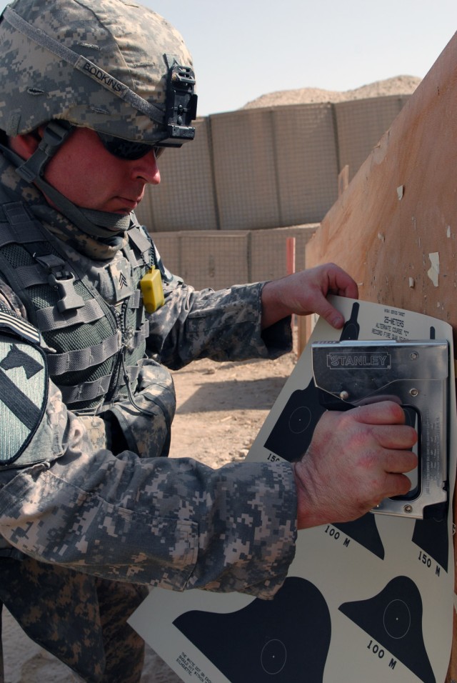 BAGHDAD - Sgt. Christopher Bodkins, from Denton Texas, assigned to Company B, Division Special Troops Battalion, 1st Cavalry Division, sets up paper qualification targets during a zero and qualification range at Caughman Range on Victory Base...