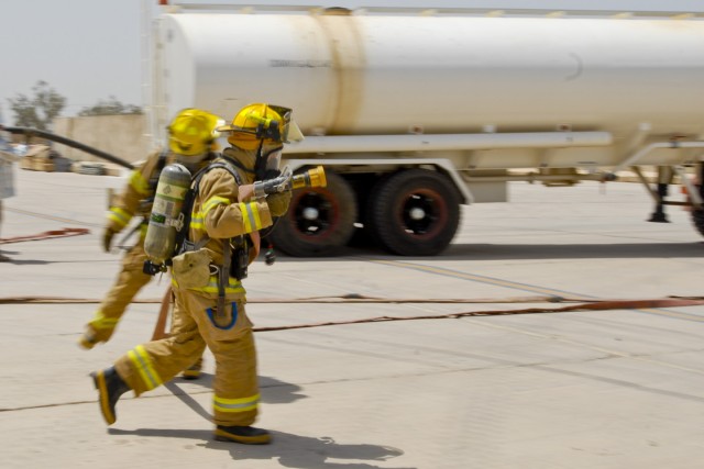 TAJI, Iraq- A firefighter from the Taji fire department moves swiftly to react to a mock fire on a CH-47F Chinook helicopter, July 17, at Camp Taji, Iraq, as part of a training exercise designed to test the firefighters familiarization with the...