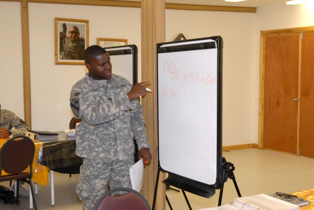 BAGHDAD - Capt. Tajudeen Ottun, the division pharmacist for the 1st Cavalry Div., who is from Long Beach, Calif., reviews one of the math problems on the final assessment test for the GT (general technical) improvement class, July 17. Twenty other...