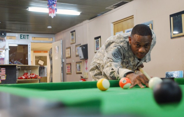Sgt. Teo Garcia plays a game of pool at the Morale, Welfare and Recreation center July 20, on Joint Security Station Loyalty, located in the 9 Nissan district of eastern Baghdad. Garcia rejoined the Army in 2007 after losing a bet to his good...