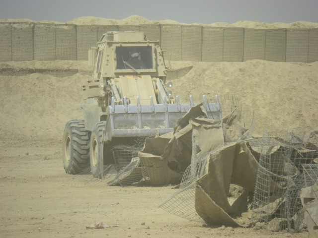 BAGHDAD - Spc. Joshua Carrington of Oneonta, N.Y., heavy equipment 

operator, 46th Engineer Combat Battalion (Heavy), 225th Engineer Brigade, 

operates the bucket loader to remove HESCO barrier debris from the old 

range separation berm and away f...