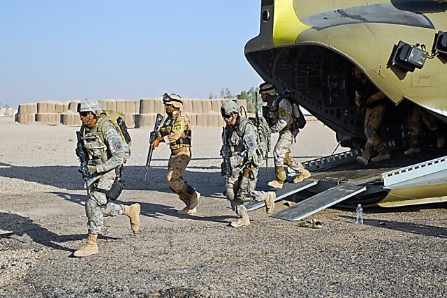 TAJI, Iraq- Soldiers from both the 3rd Brigade Combat Team, 82nd Airborne Division, and the Iraqi Army come bursting out from a CH-47F Chinook helicopter at Forward Operating Base Hammer, Iraq, July 20, as they make a final practice run before attemp...