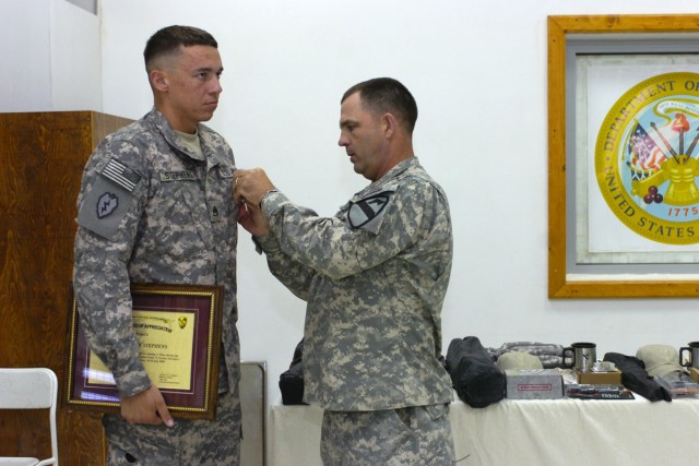 Command Sgt. Maj. James Pippin, the command sergeant major of the 3rd Heavy Brigade Combat Team, 1st Cavalry Division, presents Staff Sgt. Derek Stephens, the NCO representing the 1st Battalion, 67th Armor Regiment with an Army Commendation Medal...