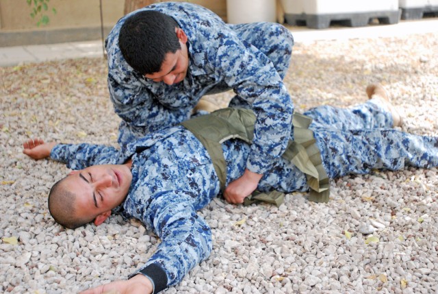 BAGHDAD - National Police medics assigned to the 4th NP Brigade, 1st NP Division practice applying a trauma wound dressing during a training event July 22 at Joint Security Station Loyalty, located in the 9 Nissan district of eastern Baghdad. ...