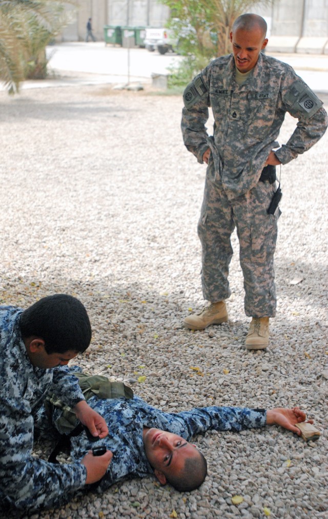 BAGHDAD - Sgt. 1st Class Juan Almonte, of New York City, a senior medic assigned to the 2nd Battalion, 505th Parachute Infantry Regiment, 3rd Brigade Combat Team, 82nd Airborne Division, Multi-National Division - Baghdad, tells a National Police...
