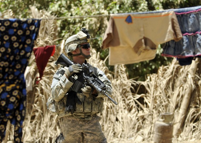 ADWANIYAH, Iraq - Sgt. Joshua Anderson, Battery B, 1st Battalion, 113th Field Artillery Regiment, 30th Heavy Brigade Combat Team, of Indian Trail, N.C., secures the outside of a home while on a joint patrol with the Iraqi Army, south of Baghdad,...