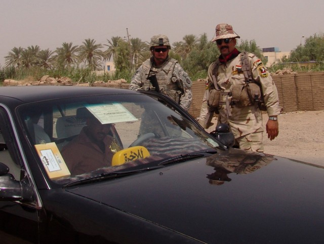 MAHMUDIYAH, Iraq -- Sgt. Jefery Fyke of Fayetteville, N.C., a driver with Company B, 120th Combined Arms Battalion, 30th Heavy Brigade Combat Team, and an Iraqi Soldier with 3rd Company, 3rd Battalion, 17th Iraqi Army Division, conduct a traffic stop...