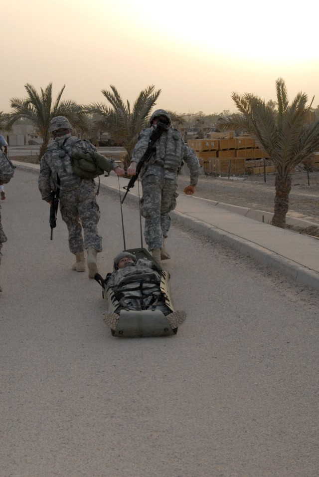 BAGHDAD - Two Division Special Troops Battalion Soldiers drag another on a sked improvised litter as part of a mile-long final training exercise designed to evaluate 18 Soldiers' skills and knowledge acquired during the past three days of combat...