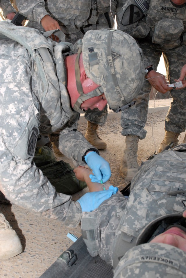 BAGHDAD -  Pfc. Kenny Lawson of Battery E, 3rd Battalion, 4th Air Defense Artillery Regiment  attached to the Division Special Troops Battalion, 1st Cavalry Division, from Philadelphia, quickly administers a saline lock and inserts an IV into the...