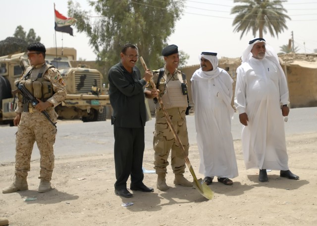 BAGHDAD - Engineer Mohammed Khalaf Hashim (left, holding shovel), Capt.  Jabbar Noury, 24th Brigade, 6th Iraqi Army Division, and religious leaders of the Zaidon community smile at the July 22 ground-breaking ceremony of the Zaidon Market road...
