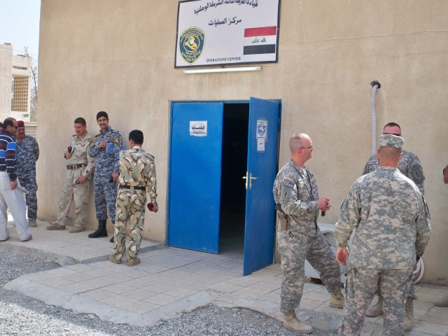 Soldiers from 3rd Division Federal Police Transition Team and Federal Police congregate outside the Combined Operations Center before the morning briefing. The 3rd Federal Police Division Transition Team assisted in the creation of a Combined Operati...