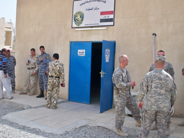 Soldiers from 3rd Division Federal Police Transition Team and Federal Police congregate outside the Combined Operations Center before the morning briefing. The 3rd Federal Police Division Transition Team assisted in the creation of a Combined...