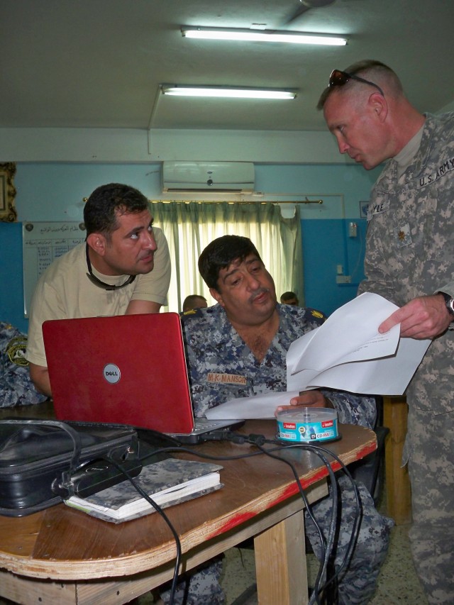 Major Marc Meyle of 3rd Division Federal Police Transition Team goes over operations with his Federal Police counterparts. The 3rd Federal Police Division Transition Team assisted in the creation of a Combined Operations Center which is now the...