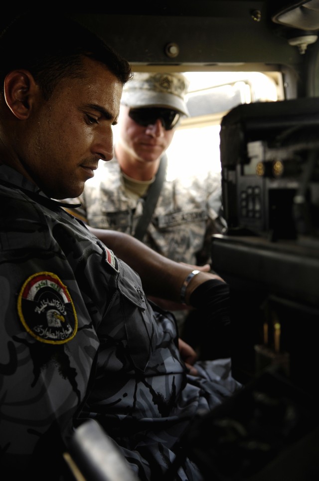 An Iraqi policeman receives Humvee (HMMWV) familiarization training from U.S. Army Sgt. James Ryan, a master driver, with Alpha Company, 215th Brigade Support Battalion, 3rd Brigade Combat Team, 1st Cavalry Division at Forward Operating Base Diamondb...