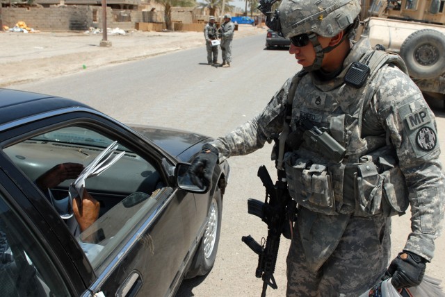 BAGHDAD - Staff Sgt. Jonathan Romero, a military police squad leader from San Antonio, assigned to the 591st MP Company, 93rd MP Battalion, 8th MP Brigade, hands out Iraqi newspapers in an effort to keep the local citizens informed in the community h...