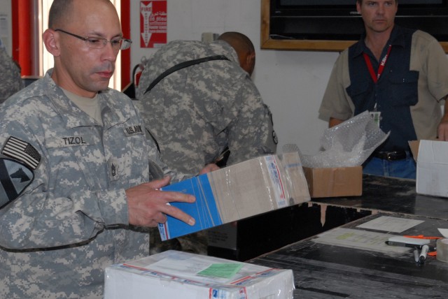 BAGHDAD - Sgt. 1st Class Eric Tizol, from San Juan, Puerto Rico, assigned to Company B, Division Special Troops Battalion, 1st Cavalry Division, prepares to mail some packages at the Camp Liberty Post Office on Victory Base Complex, July 24. Soldiers...