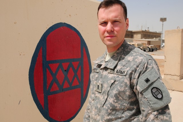 BAGHDAD -- First Lt. Scott Sharkey of the Colorado Army National Guard's 86th Military Intelligence Company stands in front of a painted 30th Heavy Brigade Combat Team patch at Forward Operating Base Falcon July 25.   The patch, the combat version of...