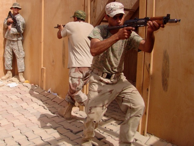 MAHMUDIYAH, Iraq -- Spc. Michael Kornegay (left) of Clinton, N.C., a gunner with Headquarters and Headquarters Company, 120th Combined Arms Battalion, 30th Heavy Brigade Combat Team located in Wilmington, N.C., watches a room clearing exercise by...