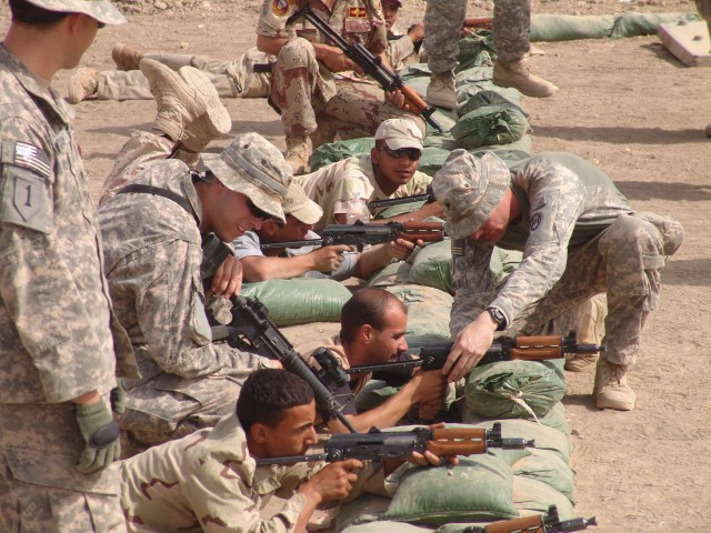 MAHMUDIYAH, Iraq - Soldiers of Headquarters and Headquarters Company, 120th Combined Arms Battalion, 30th Heavy Brigade Combat team located in Wilmington, N.C., walk the firing line at marksmanship training for soldier of  25th Brigade, 17thIraqi...