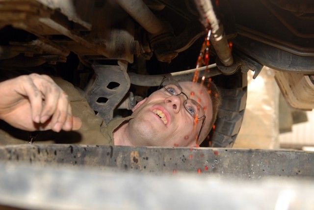 BAGHDAD - Spc. Thomas Parker of Salem, Ore., drains transmission fluid from a humvee in the Division Special Troops Battalion motor pool, here, July 24. Parker, a mechanic assigned to Headquarters Support Company, DSTB, 1st Cavalry Division at...