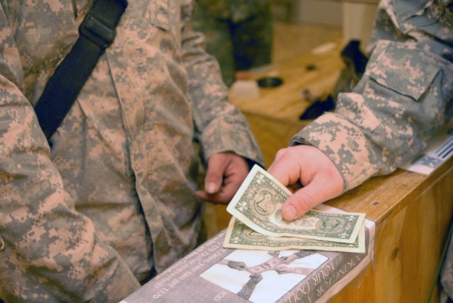 BAGHDAD, Iraq - Tavares, Fla. native Spc. Emily Pelchat (right), cashier for Detachment "Blackhawks" B, 208th Financial Management Company, 10th Sustainment Brigade, 101st Airborne Division distributes funds to Copperas Cove native Pfc. Larry Ladd...