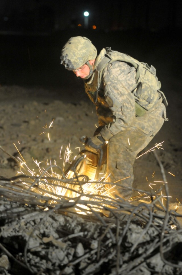 BAGHDAD - Sgt. Nicholas Rogers, 46th Engineer Combat Battalion (Heavy), 225th Engineer Brigade, a native of New Bloomfield, Pa., cuts rebar that was holding a dilapidated building together. Rogers and fellow troops from Company A, 46th ECB (H) cut ov...