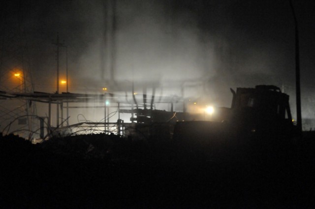 BAGHDAD - Smoke pours into the night air as bulldozer operator, Spc. Christopher Miller, Company A, 46th Engineer Combat Battalion (Heavy), 225th Engineer Brigade, of Philadelphia, knocks down the skeleton of a collapsed building in the Ghazaliyah di...