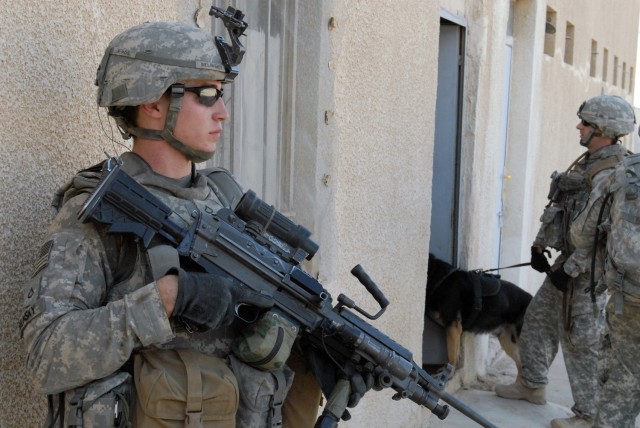 BAGHDAD - Pfc. Travis Selinsky (left), from Prescott Valley, Ariz., assigned to Company B, 2nd Battalion, 8th Cavalry Regiment, 2nd Brigade Combat Team, 1st Infantry Division, pulls security while Sgt. Nickolas Maynard, from Bangor, Maine, assigned t...