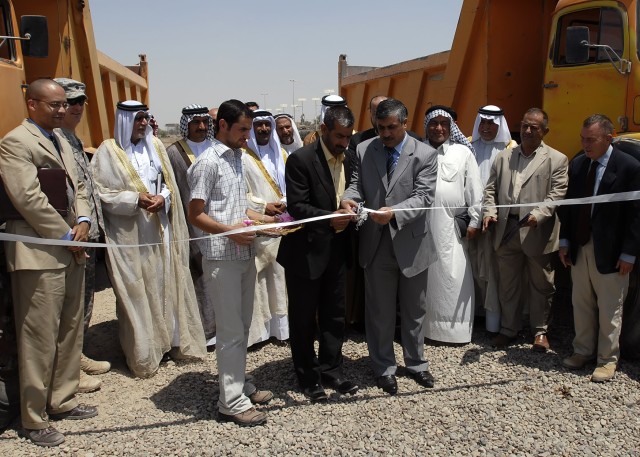 BAGHDAD - Kamil Abbas, chairman of the Abu Ghraib District Council (left center, in black suit) and Shakr Fiza, Quimaqam of Abu Ghraib, cut the ceremonial ribbon signifying the establishment of the Mobile Rural Support Team outside of the Abu Ghraib ...