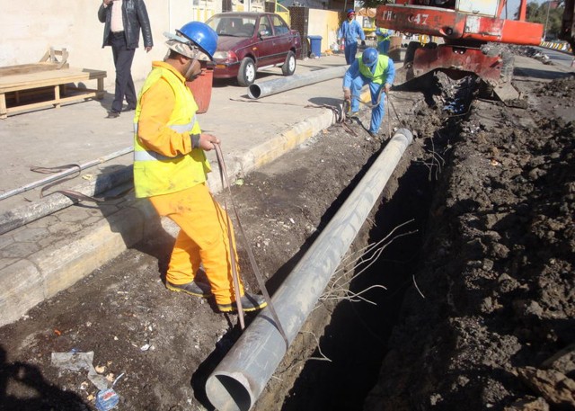 BAGHDAD - Iraqi construction workers place new sections of pipe to a sewer network in the Salhiyah neighborhood of northwest Baghdad May 25. The project was funded by Coalition forces but the plan and execution were in the hands of local Iraqi Govern...