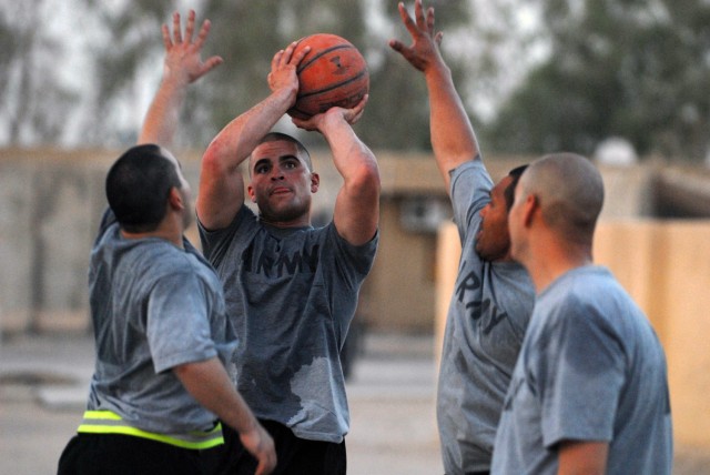 BAGHDAD - Spc. Thomas Clark (center), from Winchester, Va., assigned to 591st Military Police Company, attempts to make shot while defended by Spc. David Doxtator (left), from Keshena, Wisc., 591st MP Co. and Cpl. Paul Siko, from Pago Pago, American ...