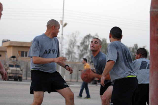 BAGHDAD - Spc. Thomas Clark (center), from Winchester, Va., assigned to 591st Military Police Company, charges toward the goal while defended by Spc. Alejandro Selaya (left) from Phoenix, assigned to 591st Military Police Co., during a friendly game ...