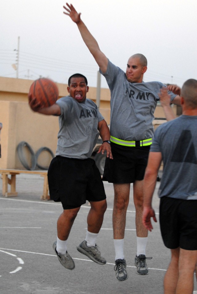 BAGHDAD - Cpl. Paul Siko (left), from Pago Pago, American Samoa, assigned to Company B, 2nd Battalion, 8th Cavalry Regiment, attempts a layup while defended by  Spc. Alejandro Selaya (right) from Phoenix, assigned to 591st Military Police Co., during...