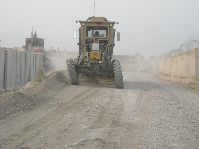 BAGHDAD - Crocker, Mo. native, Spc. James Parks (inside vehicle), heavy equipment operator, 277th Engineer Company, 46th Engineer Combat Battalion (Heavy), 225th Engineer Brigade, widens a roadway at Joint Security Station Copper southeast of Baghdad...