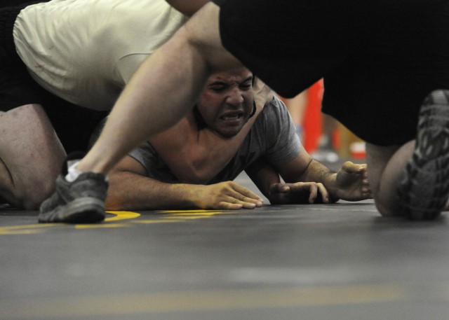 U.S. Army Sgt. Luis Villanueva, 30, of Chicago, assigned to Fox Forward Support Company, 3rd Battalion, 8th Cavalry Regiment, 3rd Heavy Brigade Combat Team, 1st Cavalry Division, tries to free himself from a headlock during a wrestling competition...