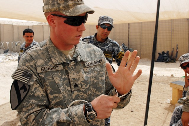 BAGHDAD - Sgt. Aaron Eckert, a cavalry scout who hails from Spokane, Wash., assigned to 1st Squadron, 7th Cavalry Regiment, 1st Brigade Combat Team, 1st Cavalry Division, teaches his Iraqi National Police counterparts how to properly flexi-cuff a...