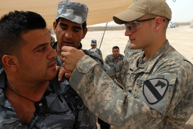 BAGHDAD -Spc. David Croft (right), a native of Plant City, Fla., and a cavalry scout gunner assigned to 1st Squadron, 7th Cavalry Regiment, 1st Brigade Combat Team, 1st Cavalry Division. Croft and his fellow scouts teach their NPs counterparts...
