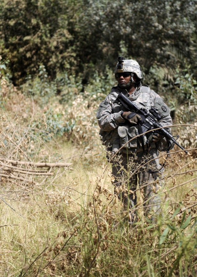 ADWANIYAH, Iraq - Staff Sgt. Kelly Little, Battery B, 1st Battalion, 113th Field Artillery Regiment, 30th Heavy Brigade Combat Team, patrols near Al Buaytha, south of Baghdad, July 25. Btry. B Soldiers, along with Iraqi soldiers from 1st Company, 1st...