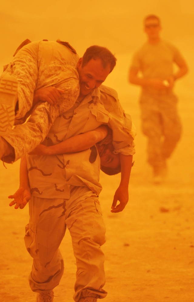 BAGHDAD - An Iraqi Soldier rushes his comrade to safety using the "buddy carry" technique as U.S. Paratroopers look on during a simulated combat exercise in the midst of a sandstorm, July 29, at Combat Outpost Carver, Iraq, located in the Salman Pak ...