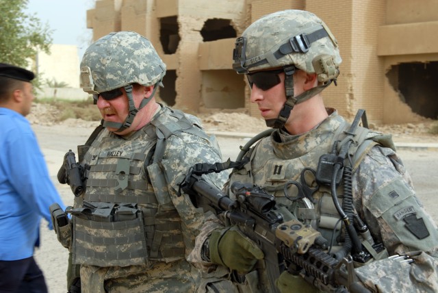 BAGHDAD - Navy Capt. Thomas Halley, (left) commander of Joint Crew Composite Squadron 1, talks with Capt. Paolo Sica of the 2nd Battalion, 112th Infantry Regiment, 2nd Brigade Combat Team, 1st Infantry Division outside the Rishala Iraqi Police...