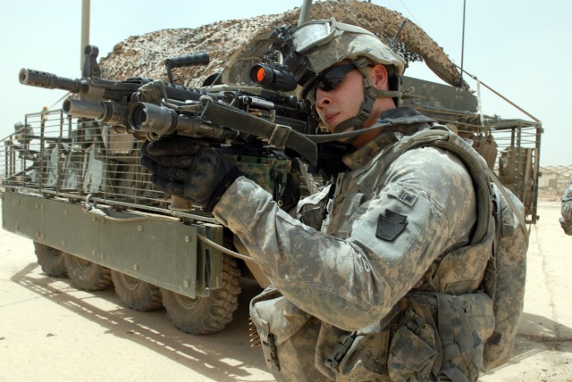 BAGHDAD - Spc. Lucas Butler scans the horizon with the sight of his M-249 Squad Automatic Weapon during an anti-improvised explosive device and anti-indirect fire mission in the Abu Ghraib area, here, July 30. Butler is an infantryman from State...