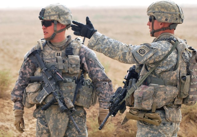SALMAN PAK, Iraq - First Lt. Jeffrey W. Wismann (right), of Winchester, Ky., discusses strategies with Capt. Dallas Cheatham, of Fayetteville N.C., in order to keep the farm roads in the town of Salman Pak safe during a foot patrol July 30 in the...