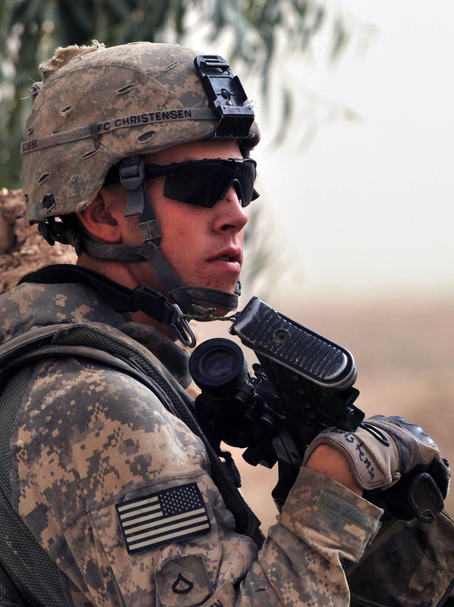 SALMAN PAK, Iraq - Pfc. Corey Christensen, of Aberdeen, Wash., pulls security near a farm in the town of Salman Pak during a foot patrol July 30 in the Ma'dain region, located outside of southeastern Baghdad. The foot patrol allowed Paratroopers to c...