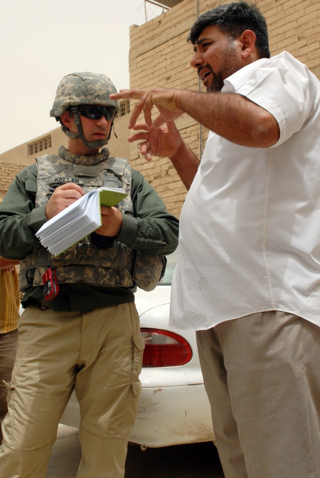 BAGHDAD - Blake Keller (left), an industrial advisor assigned to Baghdad embedded Provincial Reconstruction Team 3, discusses the production values of a tile-making factory with its owner, Kaled Waead al-Hahed, during a joint patrol to speak to facto...