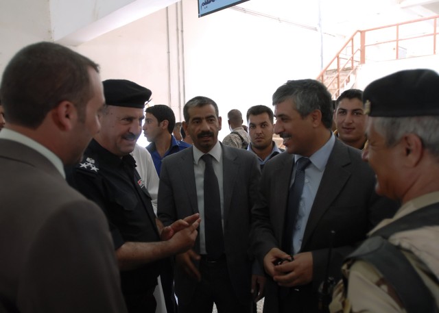 BAGHDAD - Gen. Nabil Darweesh Mohammed (left, in uniform), an Iraqi Police commander in Abu Ghraib, Kamil Abbas (right of Mohammed), chairman of the Abu Ghraib district council, and Shakr Fiza (right of Abbas), a local civic leader of Abu Ghraib,...