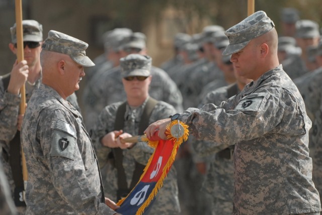 BAGHDAD - Command Sgt. Maj. John Morgan III (left), senior enlisted leader of the 56th Infantry Brigade Combat Team, 36th Infantry Division, Multi-National Division - Baghdad, along with Col. Lee Henry, commander, 56th IBCT, roll up the brigade's col...