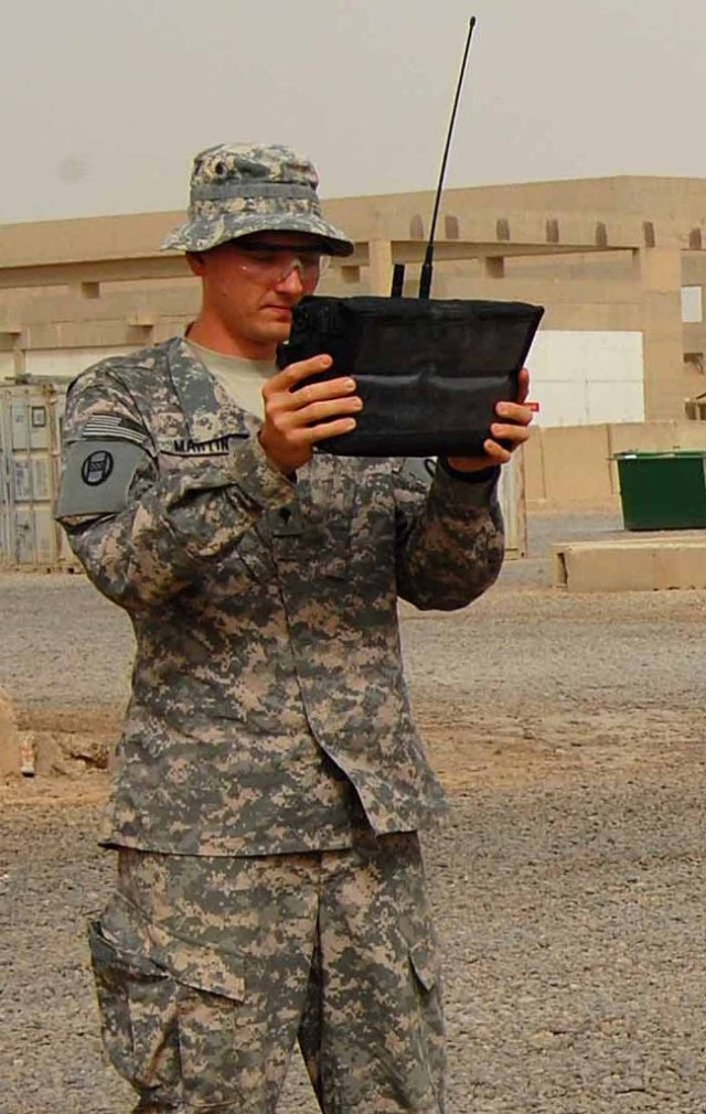 BAGHDAD -- Spc. Russell Martin, a communications specialist of 150th Armored Reconnaissance Squadron, 30th Heavy Brigade Combat Team, holds up a spectrum analyzer to check electronic systems on vehicles. He takes the reading and inputs it into a spre...