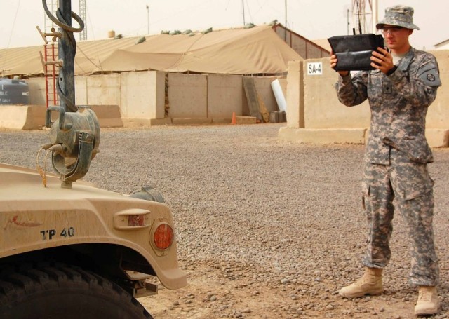 BAGHDAD -- Spc. Russell Martin, a communications specialist with the 150th Armored Reconnaissance Squadron, 30th Heavy Brigade Combat Team, checks systems on a humvee at Forward Operating Base Stryker. He inputs the information into a spreadsheet, up...